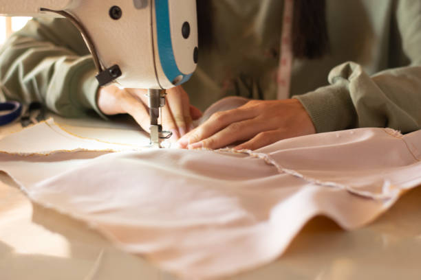 istock Handmade women use modern sewing machines to sew clothes at work. The process of manually sewing interior decoration and repairing clothes, Hobbies and small business philosophy 1977817162