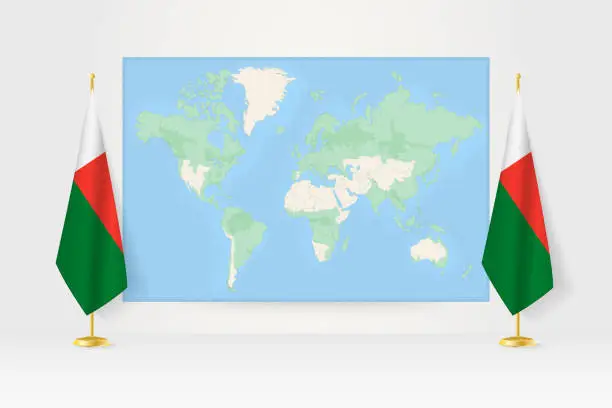 Vector illustration of World Map between two hanging flags of Madagascar flag stand.