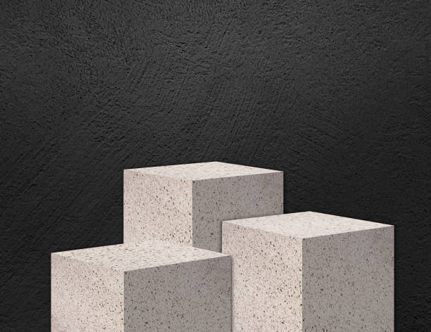 istock beige terrazzo stone step podiums for product presentation mock up, stone stgae for showing cosmetic product displayed with dark black stucco concrete wall as background, light from above. 1977825845