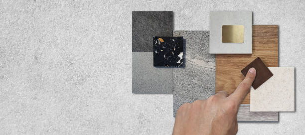 istock interior architect picks material samples including stone granite tiles, terrazzo, wooden vinyl flooring tile, gold stainless, quartz placed on grey concrete table with blank space for design. 1977825863