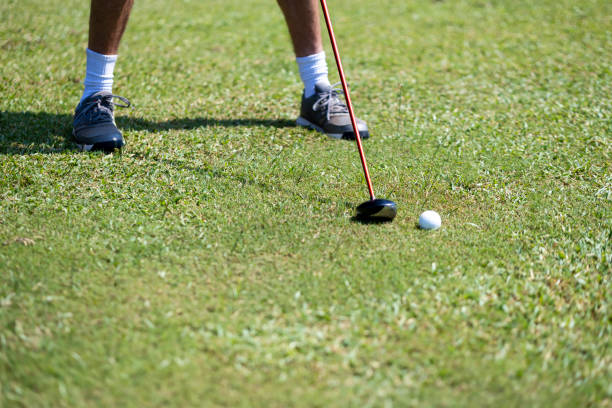 Green golf ball on the tee of a desolate golf course.
