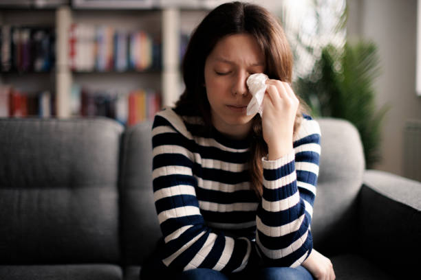 istock Young woman sitting on sofa and crying 1977837242