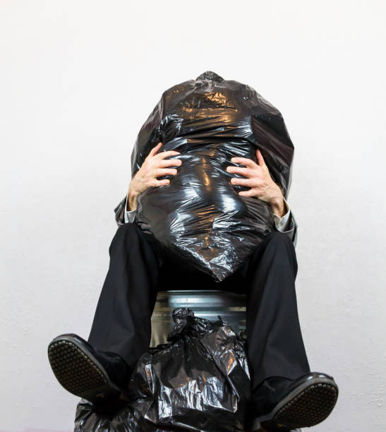 Portrait of Man Sitting in Trash Can Crushed by Rubbish. Concept of Human Waste and Garbage Person.