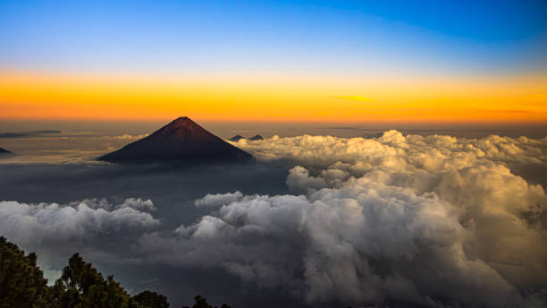 The sun near the Volcán de Agua, Antigua, Guatemala. The Volcán de Agua located near the town of Antigua, Guatemala. View from the Acatenango volcano. guatemala landscape stock pictures, royalty-free photos & images