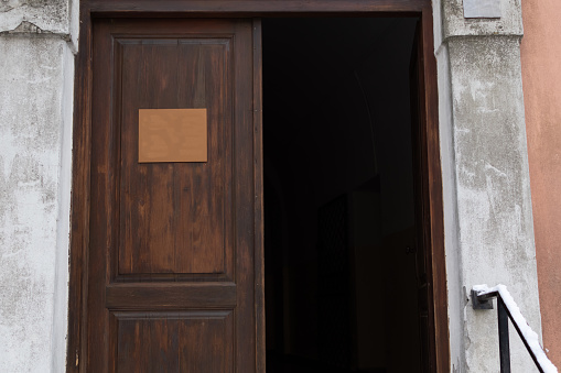 Entrance wooden open door to old house with inscription sign