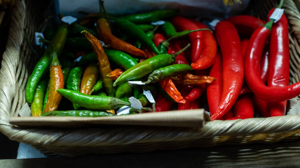 istock Green and red hot peppers in wicker basket close up 1977955963