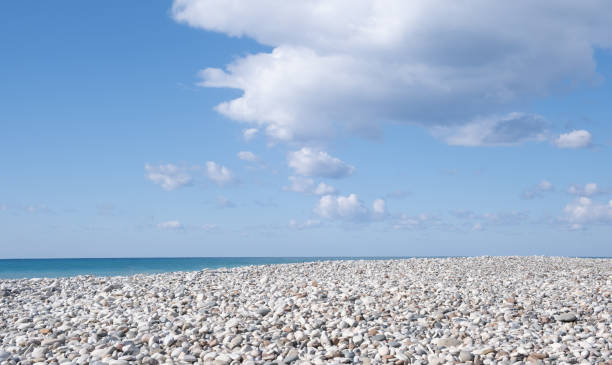 White pebble beach, cloudy sky, Nature landscape background.