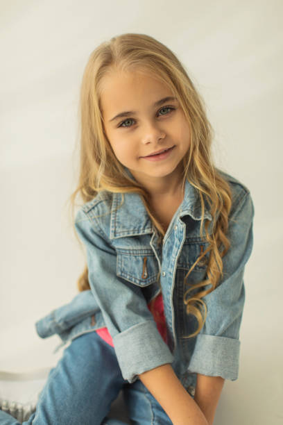 Blonde girl in denim suit in studio. Jeans