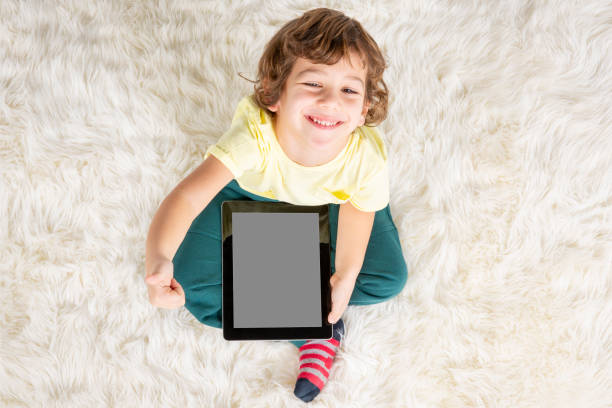 Child using digital tablet computer. Back view. Education, learning, leisure concept