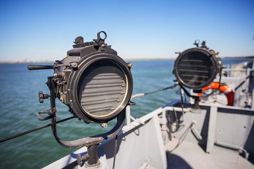 Close up shot of a military ship search light on the deck.