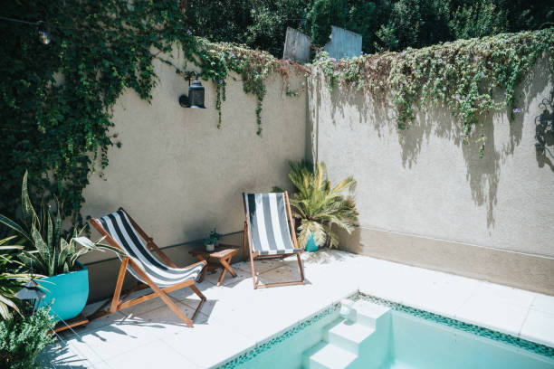 istock two sun chairs at swimming pool in patio 1978084650