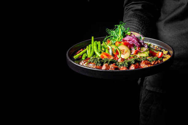 istock Men's waiter hands hold a Roastbeef salad with vegetables on plate 1978092521