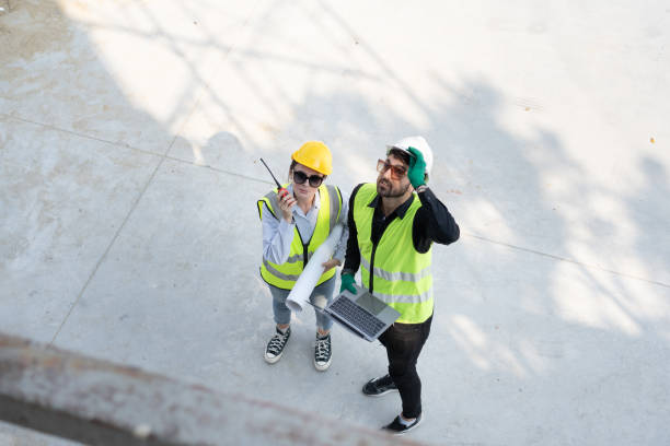 istock Caucasian engineer man and woman working with paper work at construction site 1978130557