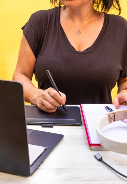 unrecognizable person using a graphics tablet and a laptop. work, study and hobbies concepts. - business person technology digital tablet using computer ストックフォトと画像