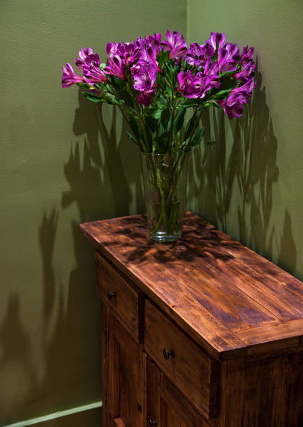 istock Rustic interior with lily flowers bouquet on vintage chest 1978219043