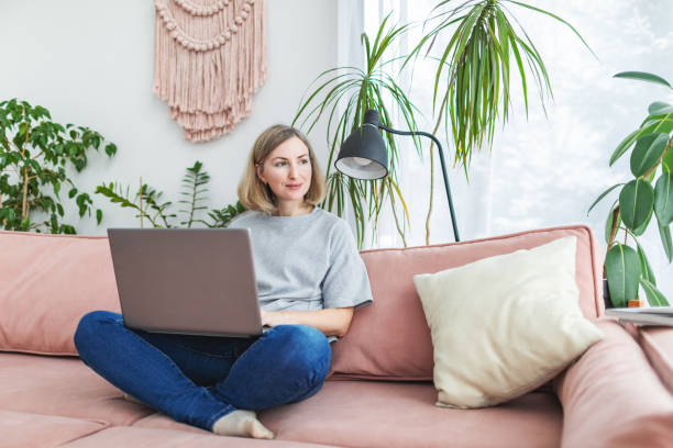 istock Mid adult woman working from home using laptop 1978275239