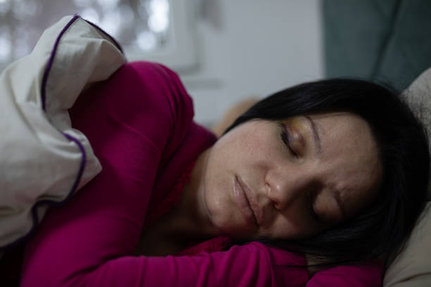 Smiling young woman sleeping in her bed in the late morning, healthy lifestyle and relax concept