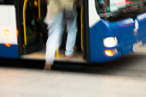 A man stepped onto the bus which has stopped at the station