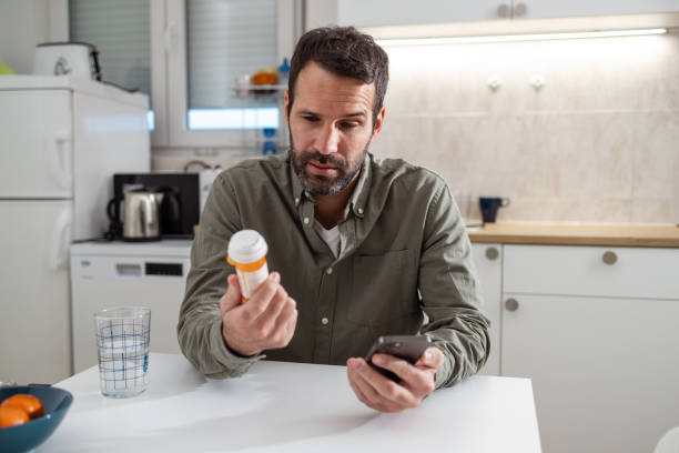 istock A mid adult man is looking at a pill bottle 1978408026
