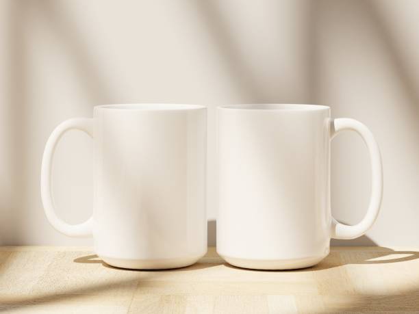 istock Two white coffee cups 15 oz with soft shadows from window silhouette on a wooden floor 1978414872