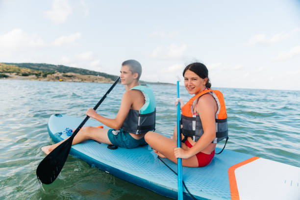istock Teenagers enjoys summer days on the beach riding a  SUP paddle board 1978431116