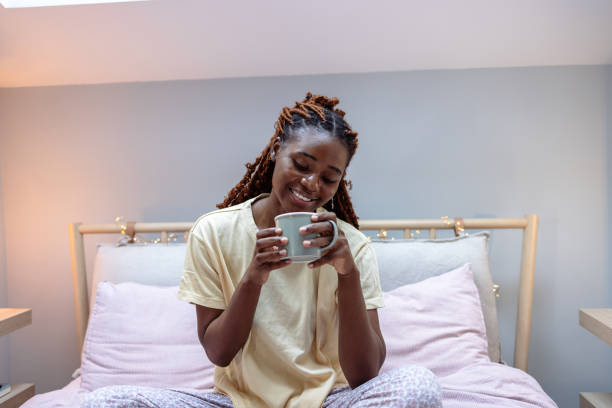 istock Young woman enjoying her morning coffee in bed 1978482484