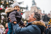 Happy father holding his son on a Christmas day in Prague, Czech Republic.