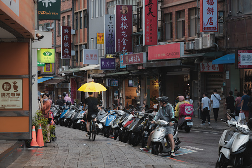 Taipei, Taiwan - October 1, 2023: Busy, colourful urban people and street scenes in the bustling Tamsui District, on a rainy day in Taipei, Taiwan.