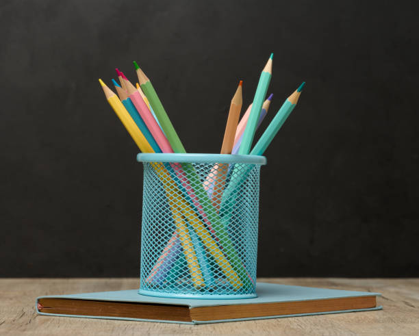 istock Multi-colored wooden pencils on a black chalk board background 1978536904
