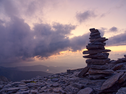 Rocks stacking pyramid with breathtaking sunset view. Mountain Olympus, Greece