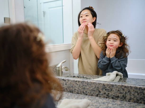 istock Mother and Daughter Washing Faces 1978576471