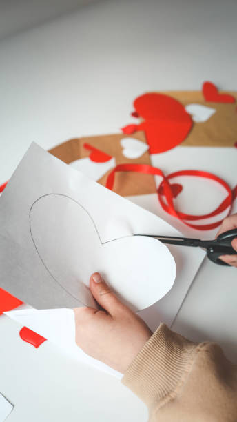 istock Child cuts out a postcard from paper, creativity for mom 1978613467