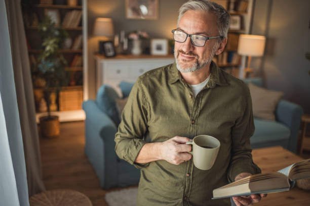 istock A mature man with an educated expression and a calm demeanor is enjoying a beautiful moment by the window. 1978617623