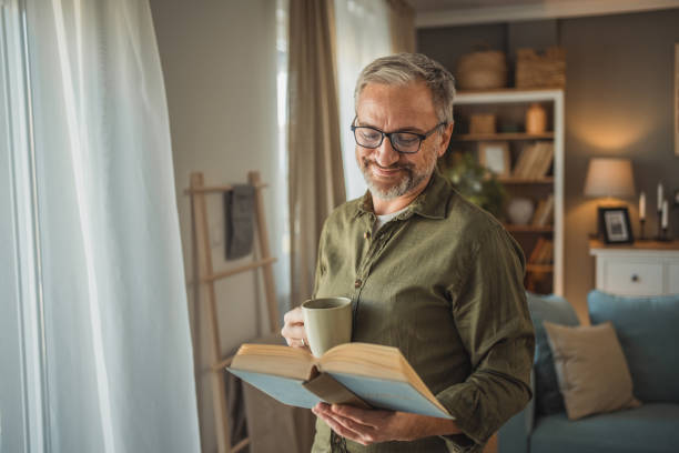 istock A mature man with an educated expression and a calm demeanor is enjoying a beautiful moment by the window. 1978617624