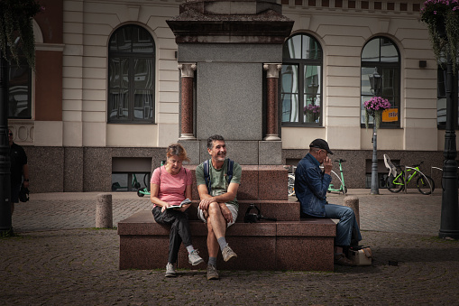 Picture of two tourists, a middle aged couple, sitting and resting in the city center of riga, latvia.