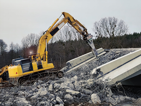 Excavator destructing bridge on the construction site