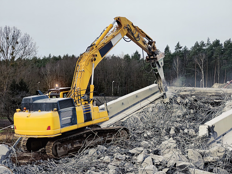 Excavator destructing bridge on the construction site