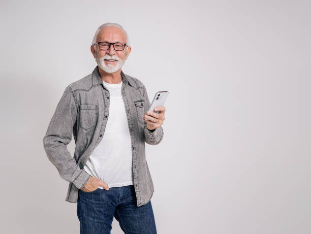 istock Smiling senior male executive texting over mobile phone and posing confidently on white background 1978677593