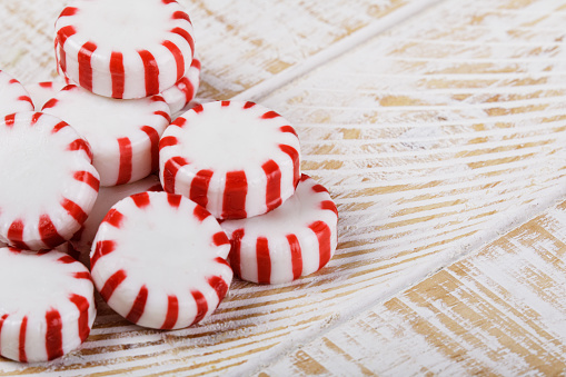 Close up of Peppermint Candies isolated on a white wooden background with copy space