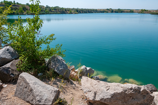 View of the flooded granite quarry with turquoise clear water, Ukraine