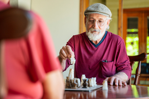 Two elderly people are playing chess in the retirement home