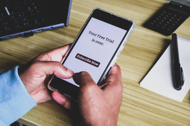 istock Person using mobile phone displaying your free trial is over subscribe now message. Selective focus. 1978753544