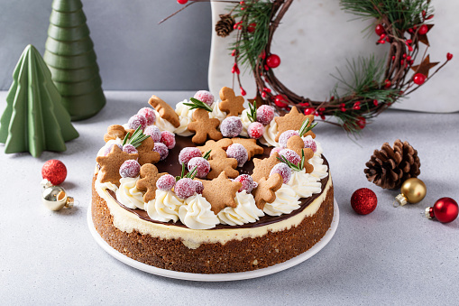 Christmas cake decorated with gingerbread cookies and sugared cranberries, festive holiday cheesecake idea