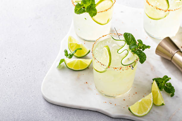 Cucumber and lime spicy margarita with chili powder on rim Cucumber and lime spicy margarita with chili powder on rim and thin cucumber slice garnish lime basil plant stock pictures, royalty-free photos & images