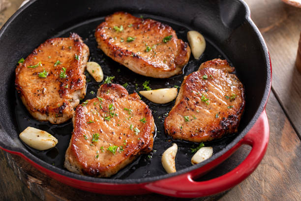 istock Pork chops seared in a cast iron pan with garlic 1978781322