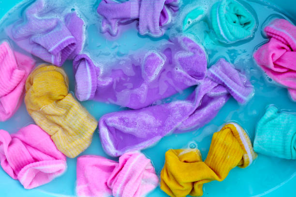 istock Dirty socks soaked in water, dissolving detergent in basin. 1978781852