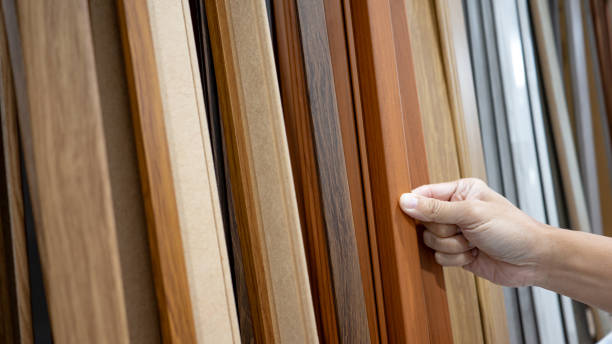 Hand picking sample of wood plank material in home design store