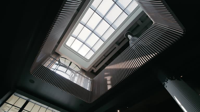 Modern Atrium Ceiling View. The view of a modern atrium ceiling with geometric patterns and natural light.