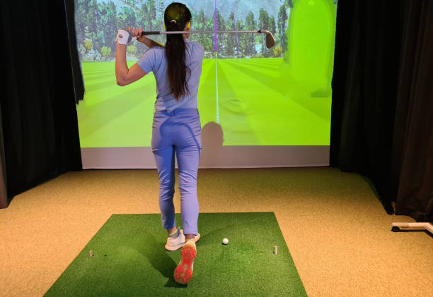 istock Woman practicing golf swing in modern indoor facility with golf simulator and large screen display 1978841719