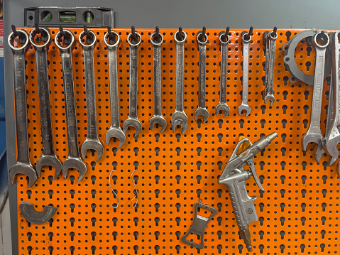 A photo showcasing a variety of wrenches neatly arranged and hanging on a wall.